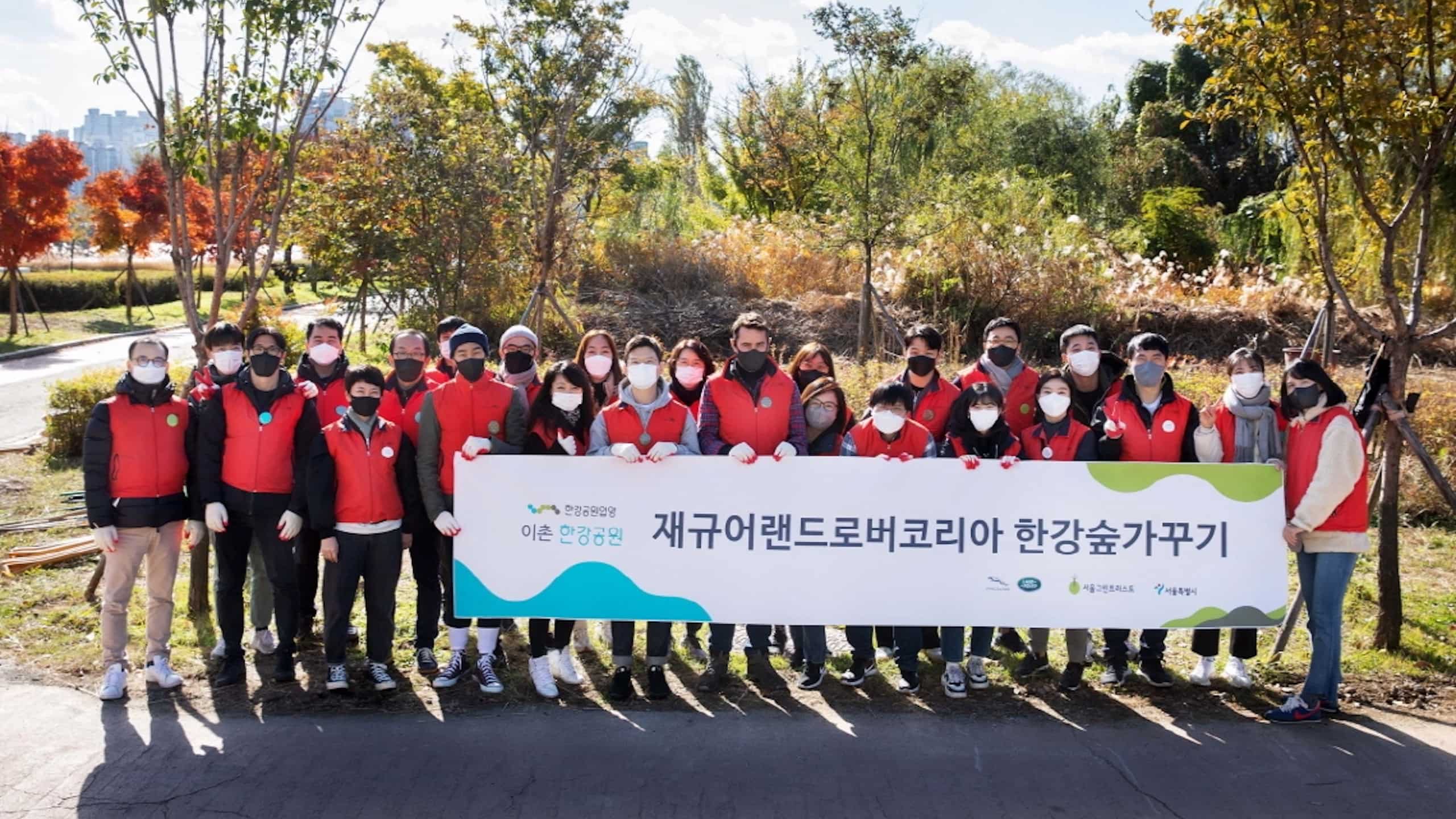 Jaguar Land Rover Korea volunteer standing with banner in hand
